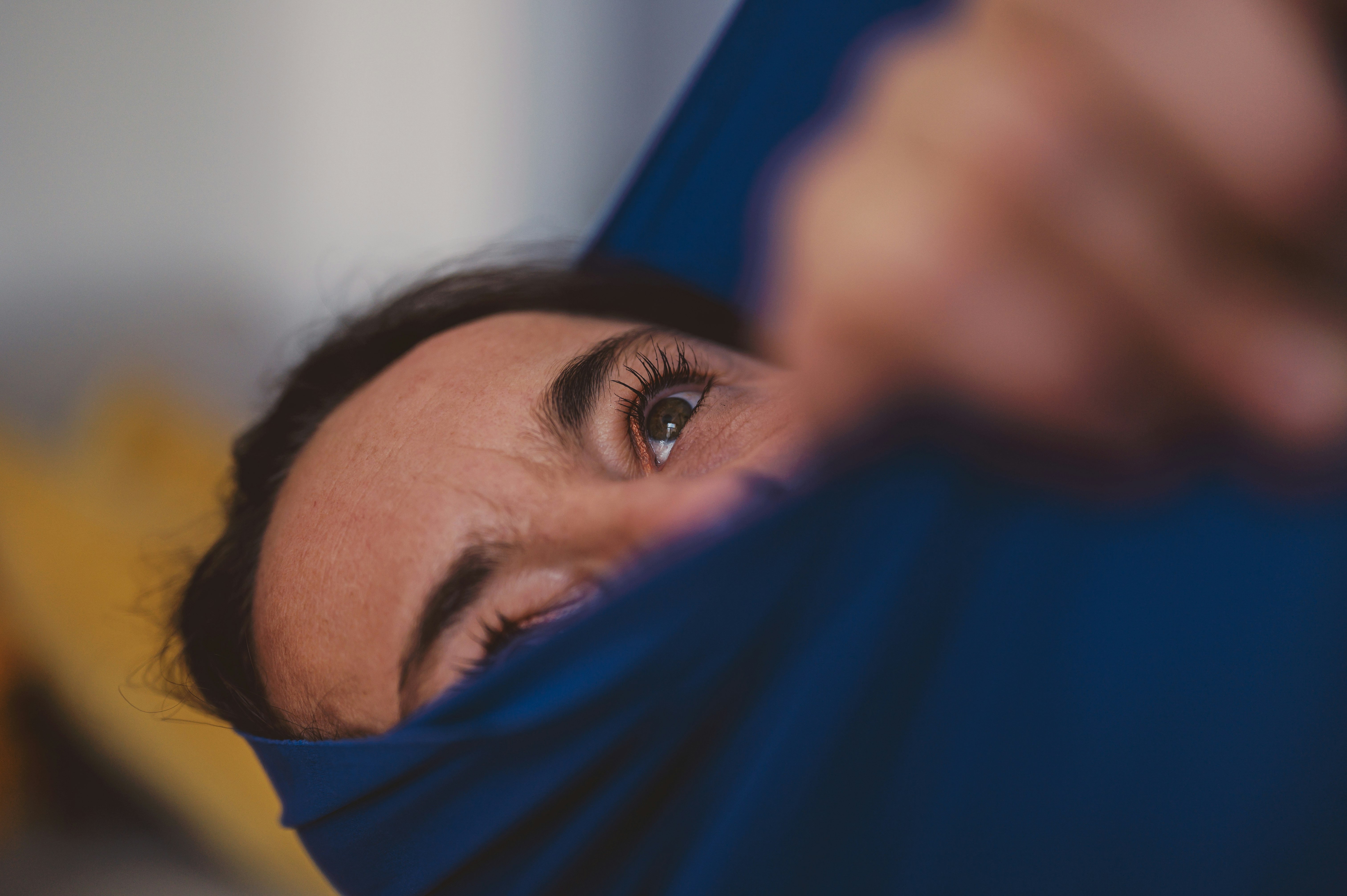 man covering his face with blue textile